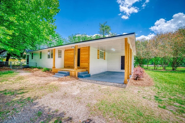 exterior space with driveway, fence, and a carport