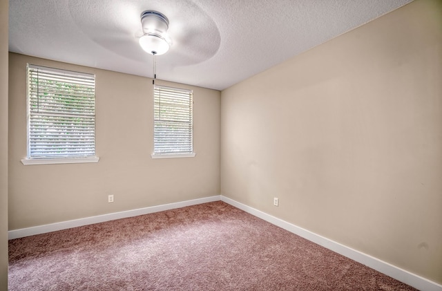 unfurnished room with a textured ceiling, baseboards, and carpet flooring