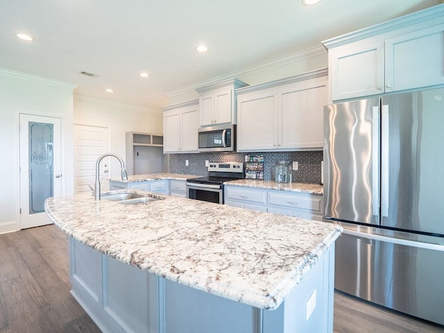 3956 Crusader Ct, Valdosta, GA 31605 - kitchen featuring appliances with stainless steel finishes, crown molding, dark wood-type flooring, a kitchen island with sink, and tasteful backsplash