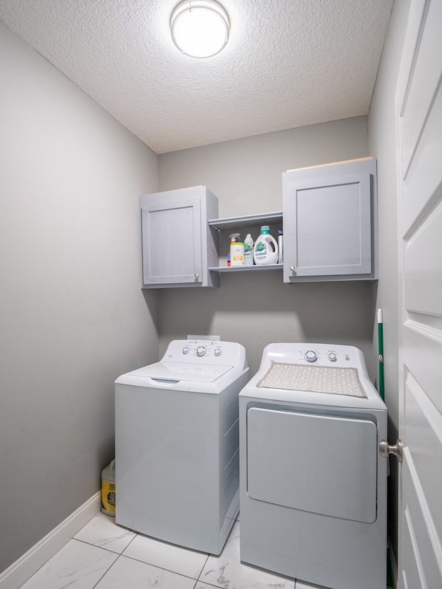 3956 Crusader Ct, Valdosta, GA 31605 - laundry room with washing machine and dryer, cabinet space, light marble finish floors, and a textured ceiling