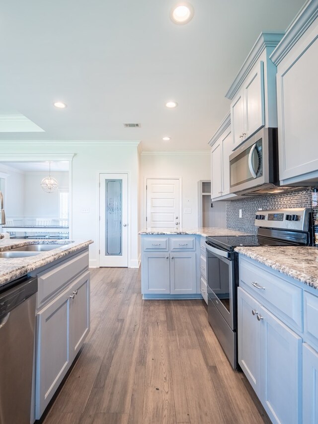3956 Crusader Ct, Valdosta, GA 31605 - kitchen with appliances with stainless steel finishes, ornamental molding, wood finished floors, backsplash, and recessed lighting