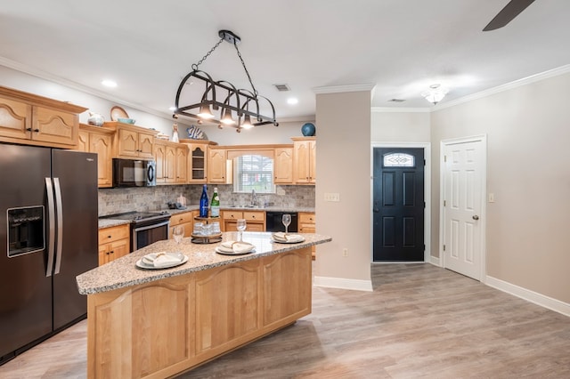 561 Sevilla Spring Cir, Lake Park, GA 31636 - kitchen with black appliances, a kitchen island, decorative backsplash, a sink, and light stone countertops