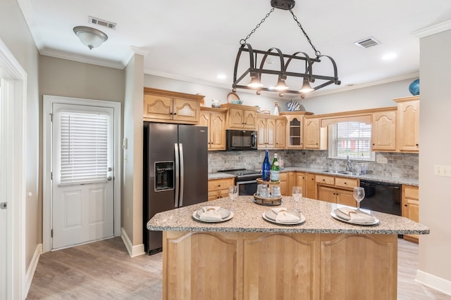 561 Sevilla Spring Cir, Lake Park, GA 31636 - kitchen with black appliances, light wood finished floors, a center island, tasteful backsplash, and ornamental molding