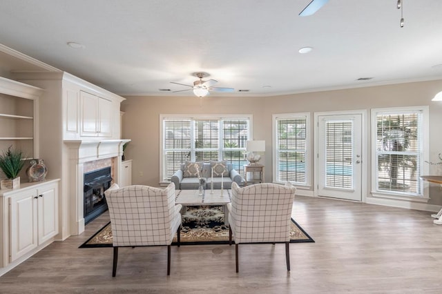 561 Sevilla Spring Cir, Lake Park, GA 31636 - living area with a ceiling fan, a tile fireplace, crown molding, wood finished floors, and baseboards