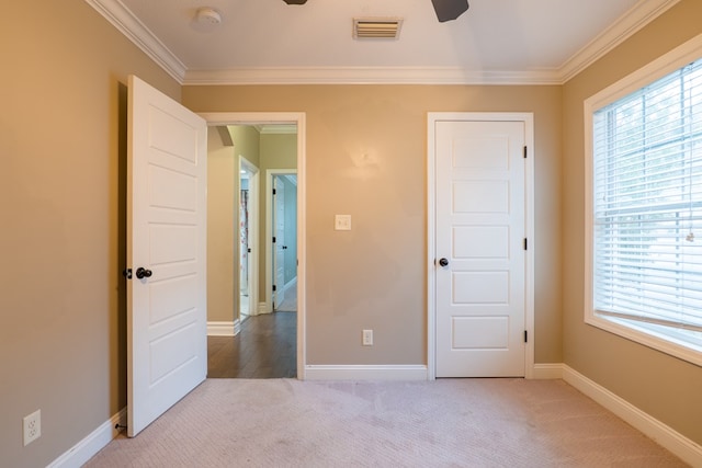 unfurnished bedroom featuring crown molding, ceiling fan, and carpet