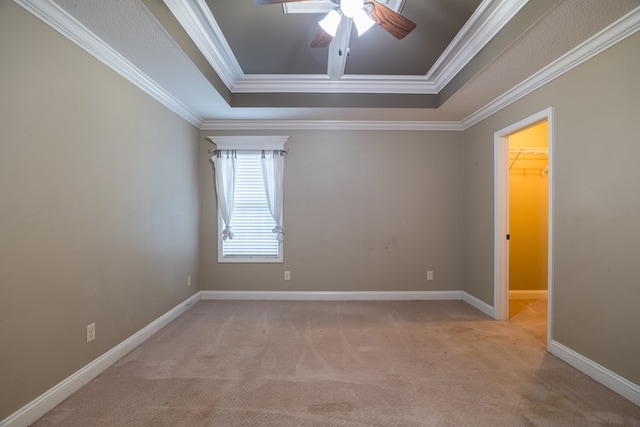 spare room featuring crown molding, light colored carpet, a raised ceiling, and ceiling fan