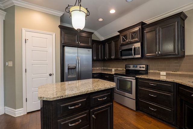 kitchen featuring dark wood-type flooring, lofted ceiling, a kitchen island, stainless steel appliances, and decorative backsplash