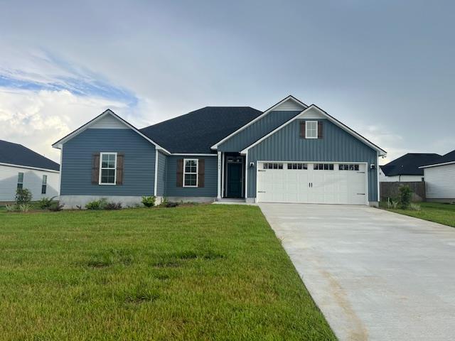 view of front of house featuring a garage and a front lawn