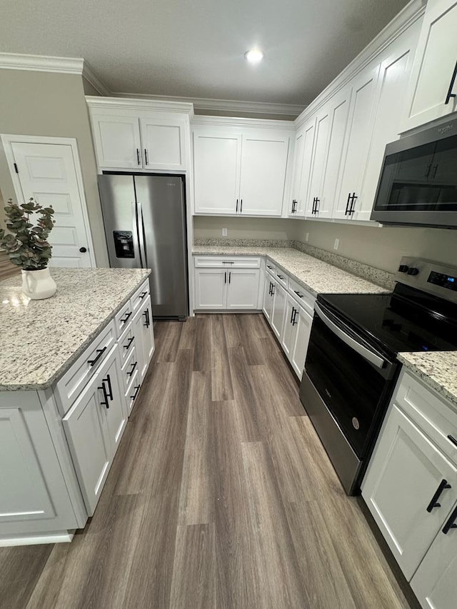 kitchen with crown molding, stainless steel appliances, and white cabinetry