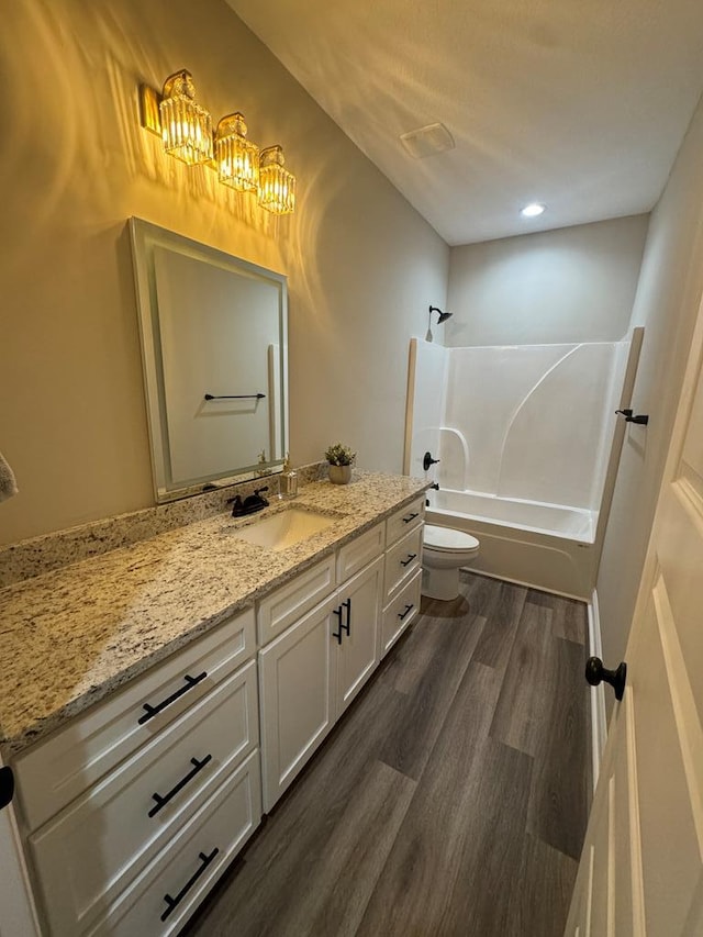 full bathroom with toilet, hardwood / wood-style flooring, vanity, and bathtub / shower combination