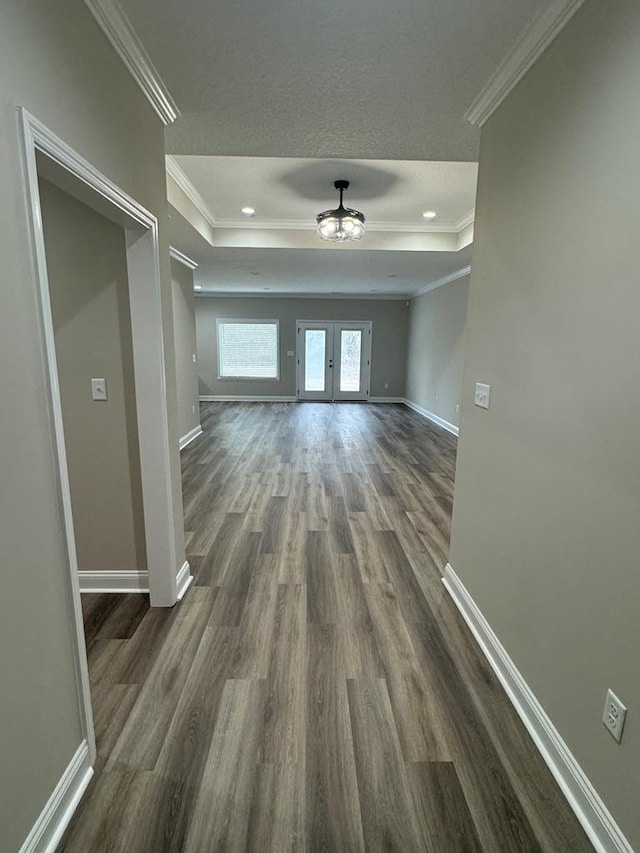 unfurnished living room featuring ceiling fan, a tray ceiling, crown molding, and dark hardwood / wood-style floors