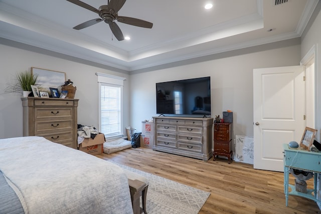 bedroom featuring a tray ceiling, ceiling fan, light hardwood / wood-style flooring, and ornamental molding