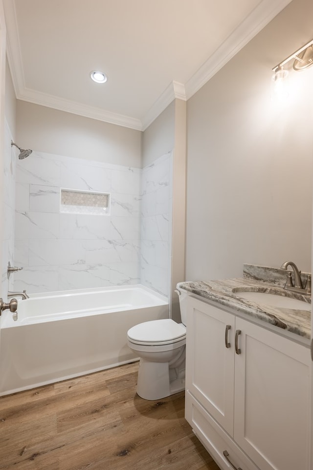 full bathroom featuring ornamental molding, tiled shower / bath combo, vanity, wood-type flooring, and toilet