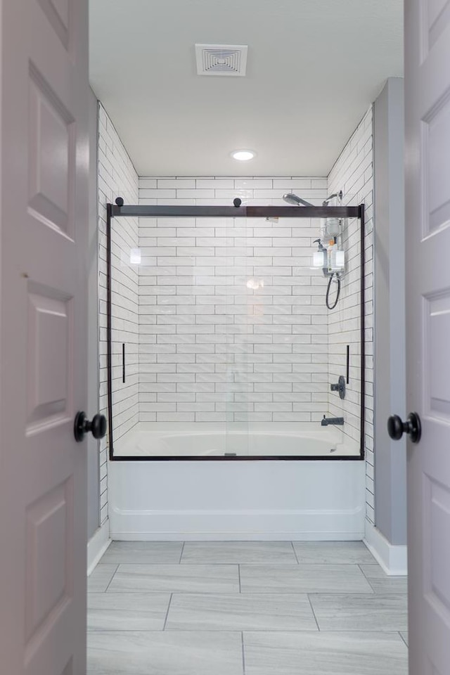 bathroom featuring bath / shower combo with glass door