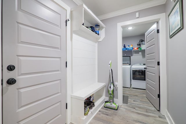 mudroom with light wood-type flooring, ornamental molding, and washing machine and clothes dryer