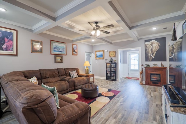 living room with beamed ceiling, ornamental molding, ceiling fan, light hardwood / wood-style flooring, and coffered ceiling