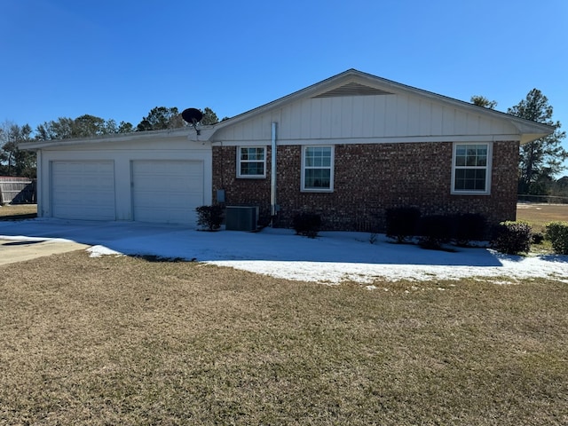 single story home with cooling unit, a garage, and a front lawn