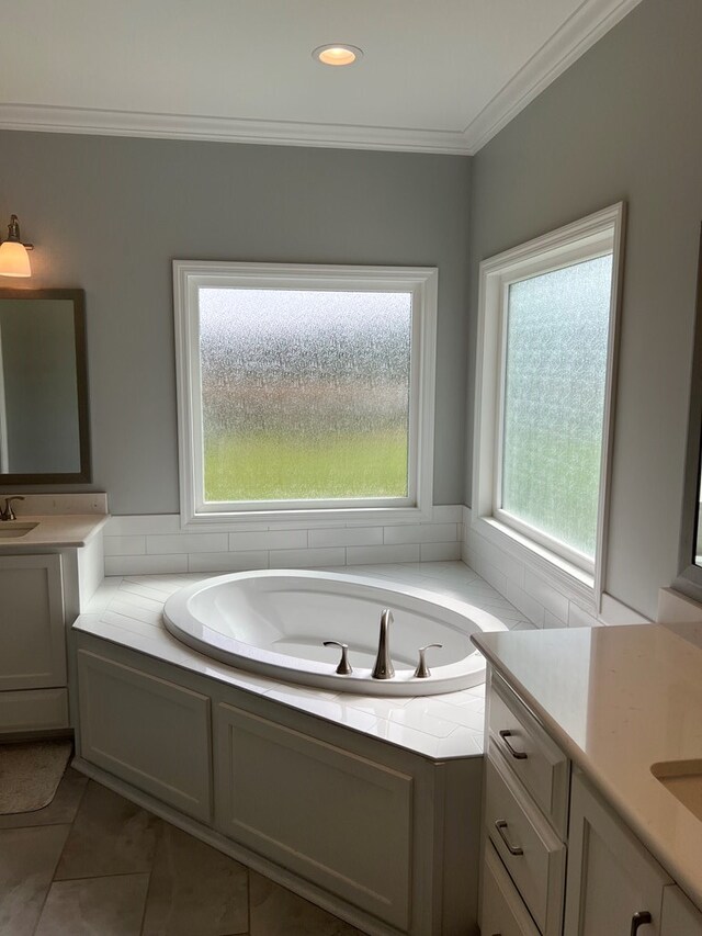 bathroom featuring vanity, crown molding, a wealth of natural light, and a tub