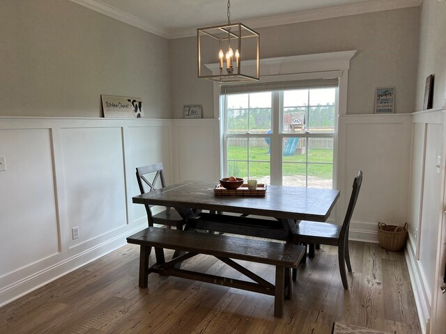 dining space featuring a chandelier, hardwood / wood-style flooring, and crown molding