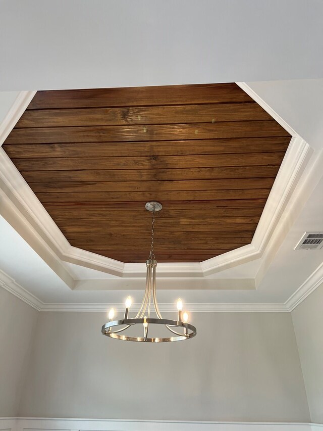 room details with an inviting chandelier, a raised ceiling, ornamental molding, and wood ceiling