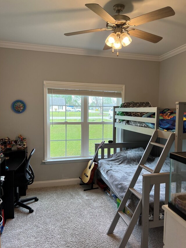 carpeted bedroom with ceiling fan and ornamental molding