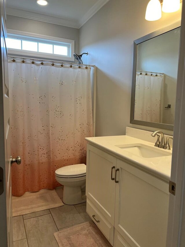 bathroom with tile patterned floors, vanity, toilet, and crown molding