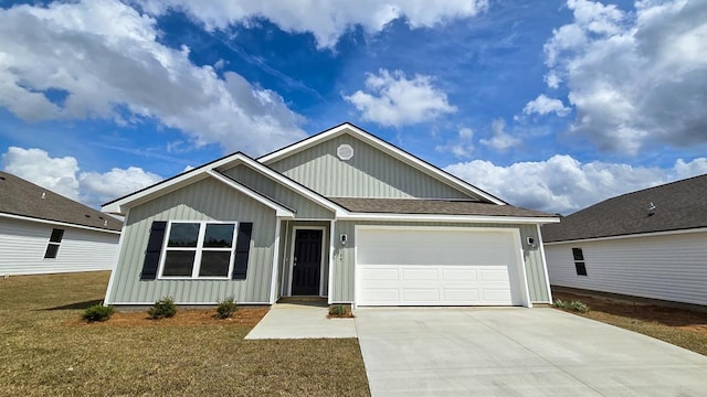 ranch-style home with a shingled roof, a front yard, driveway, and an attached garage