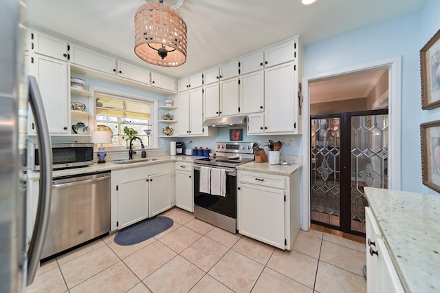 kitchen with appliances with stainless steel finishes, white cabinetry, sink, light tile patterned floors, and crown molding