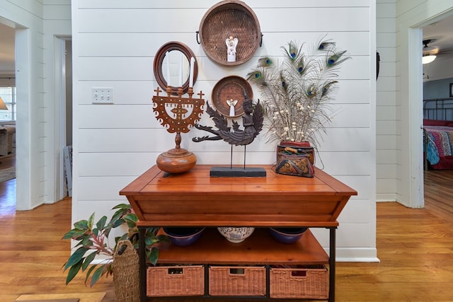 interior details featuring hardwood / wood-style floors and wooden walls