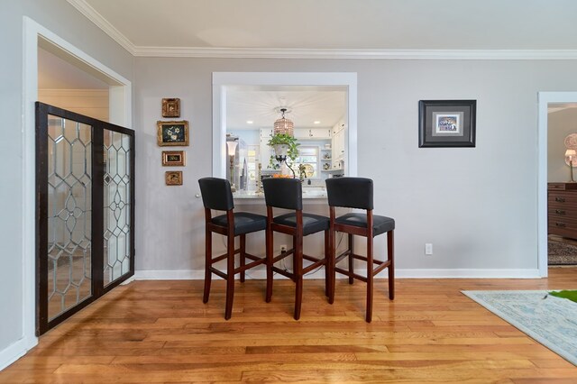 dining space with hardwood / wood-style flooring and ornamental molding