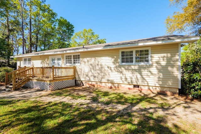 back of property featuring a yard and a wooden deck