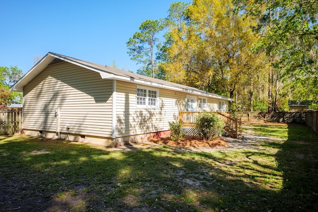 view of home's exterior with a deck and a lawn