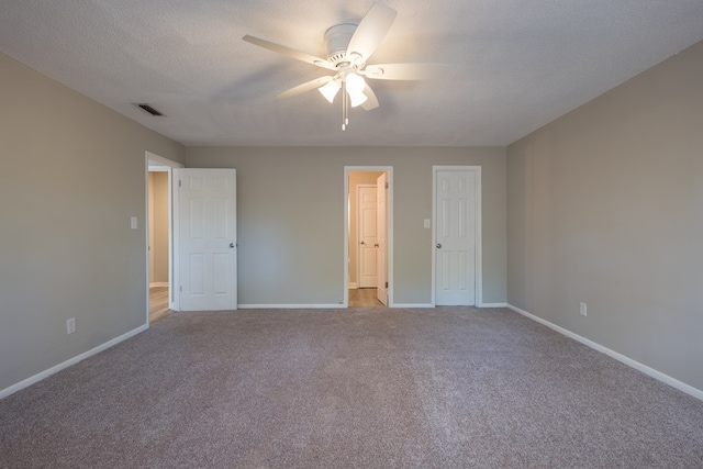 unfurnished bedroom featuring a textured ceiling, light colored carpet, and ceiling fan