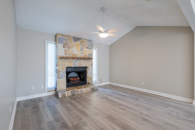 unfurnished living room featuring ceiling fan, a fireplace, wood-type flooring, and vaulted ceiling