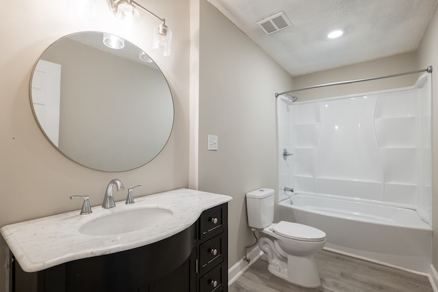 full bathroom with shower / bathtub combination, a textured ceiling, vanity, hardwood / wood-style flooring, and toilet