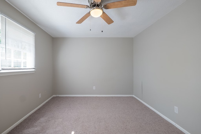 carpeted empty room featuring ceiling fan and a textured ceiling