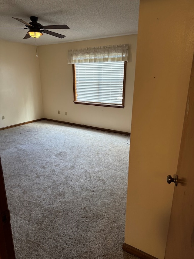 spare room featuring carpet, ceiling fan, a textured ceiling, and baseboards