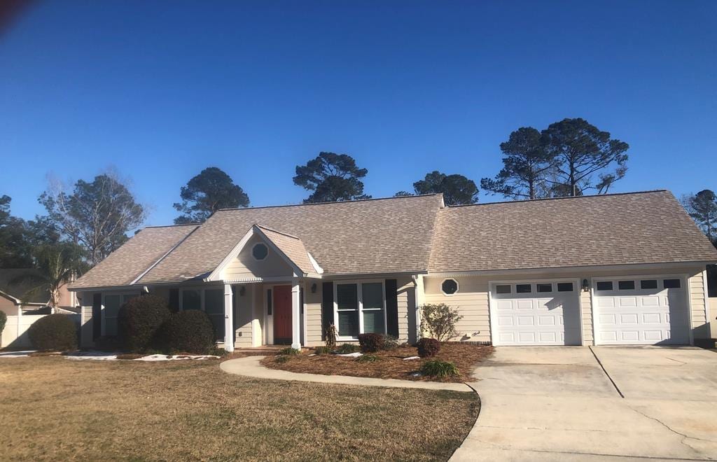 view of front of property with a garage and a front lawn