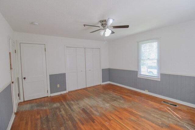 1115 Albert Rd, Valdosta, GA 31601 - unfurnished bedroom with wood-type flooring, wainscoting, and a ceiling fan