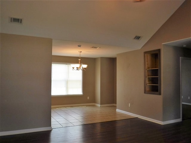 3575 Beulah Cir, Valdosta, GA 31605 - spare room featuring wood finished floors, a chandelier, built in features, and lofted ceiling