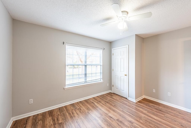 unfurnished bedroom featuring ceiling fan, a closet, a textured ceiling, and light wood-type flooring