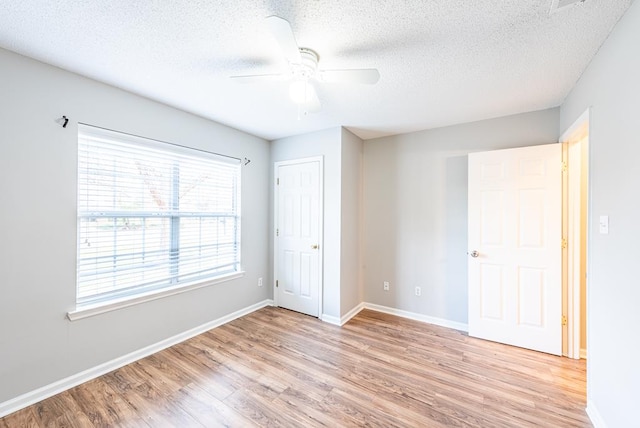 unfurnished bedroom featuring ceiling fan, light hardwood / wood-style floors, and a textured ceiling