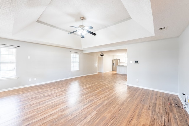 empty room featuring a textured ceiling, light hardwood / wood-style floors, and ceiling fan