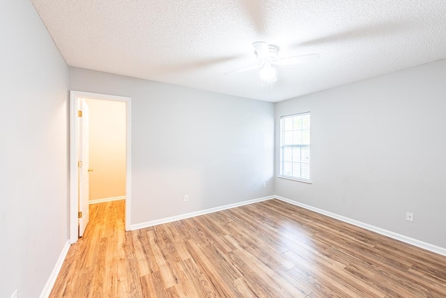 empty room featuring ceiling fan, a textured ceiling, and light hardwood / wood-style flooring