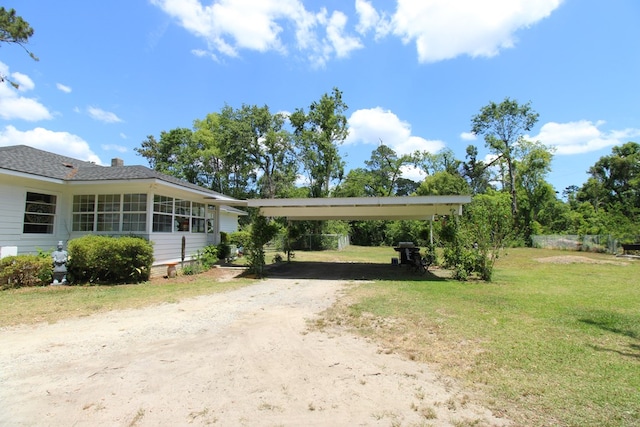 view of front of house featuring a carport, driveway, and a front lawn