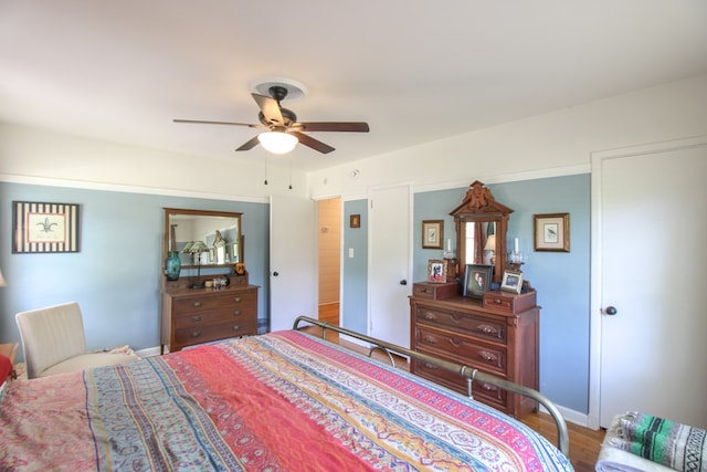 bedroom featuring a ceiling fan, baseboards, and wood finished floors