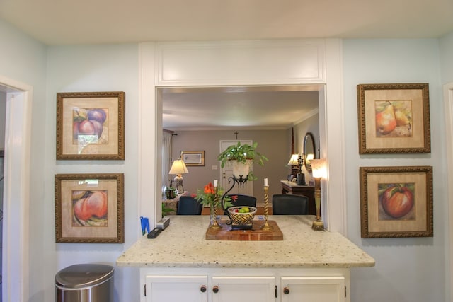 kitchen featuring ornamental molding, white cabinets, and light stone countertops