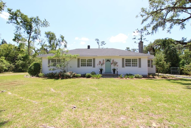 ranch-style house featuring a chimney and a front yard