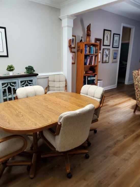 dining area featuring ornate columns, crown molding, and hardwood / wood-style floors