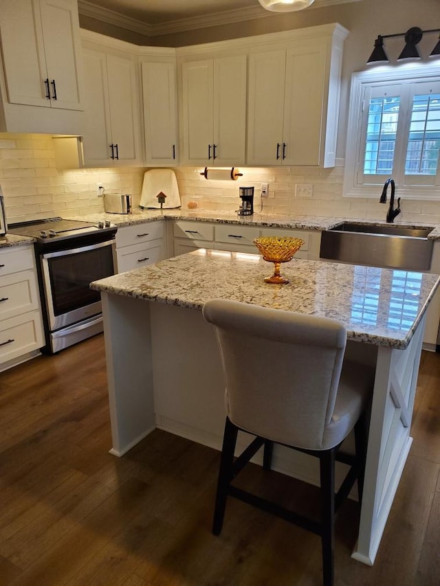 kitchen featuring a breakfast bar, white cabinetry, sink, dark wood-type flooring, and stainless steel electric range